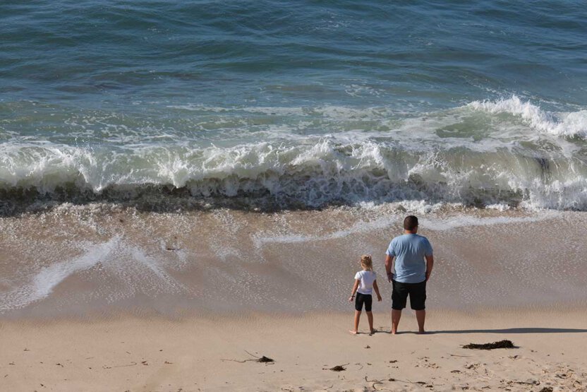 Vater und Kind warten auf eine Welle, Bretagne