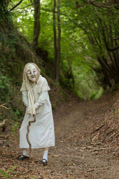Alte Frau im Wald mit Stock in der Bretagne